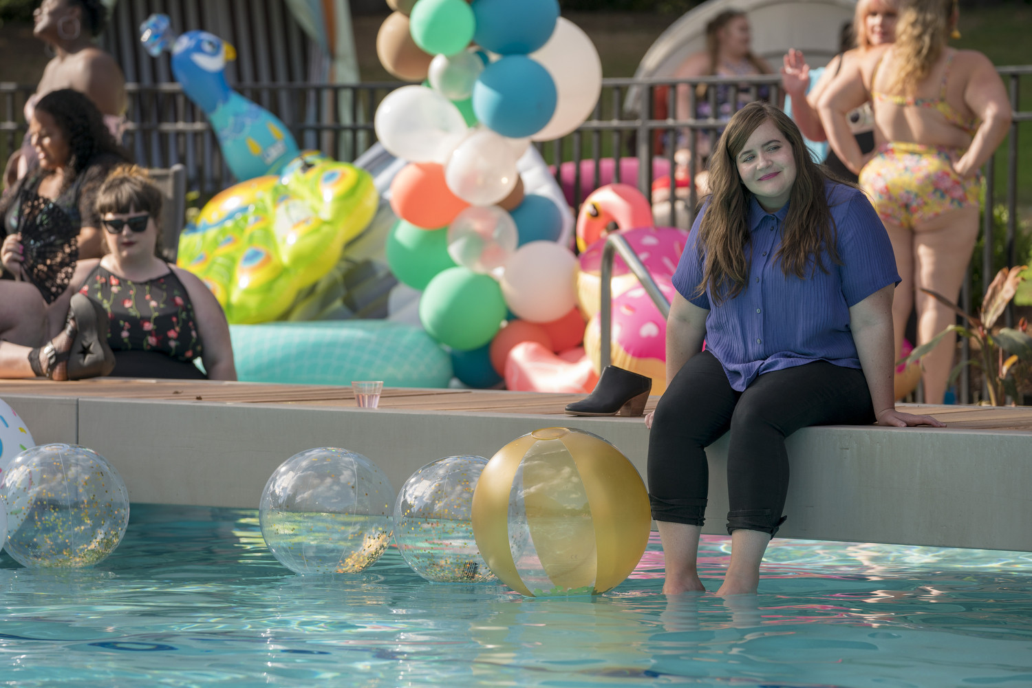 Aidy Bryant with her legs in the pool