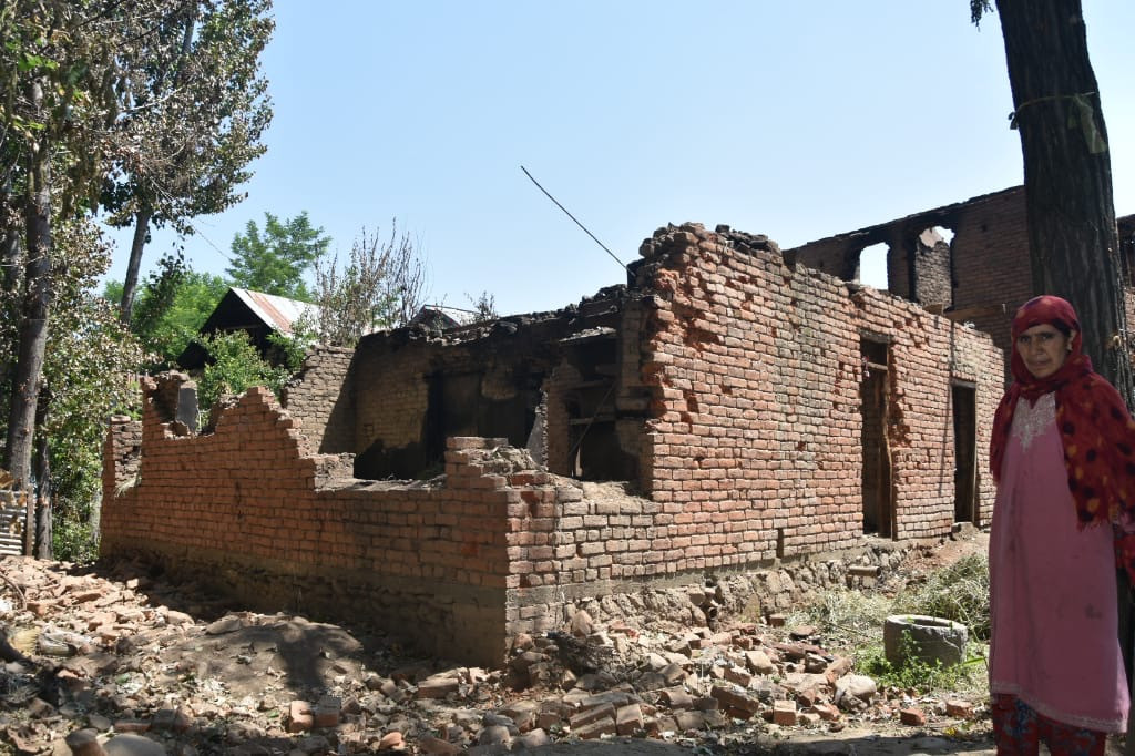 1593176756164-A-woman-Manzoor-Ahmed-Reshis-wife-stands-near-her-destroyed-house-in-Reban-Shopian-PC-Bhat-Mubashir